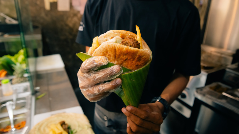 Pita sandwich wrapped in paper to stop it from falling apart