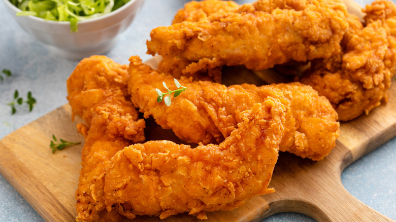 Chicken tenders served on a wooden tray