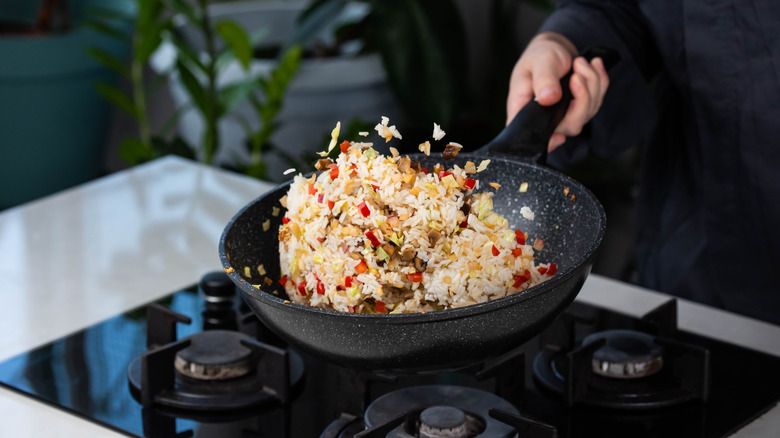 close up of fried rice being tossed in a frying pan