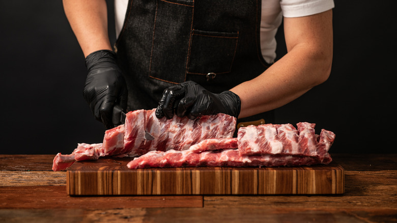 Person slicing pork ribs