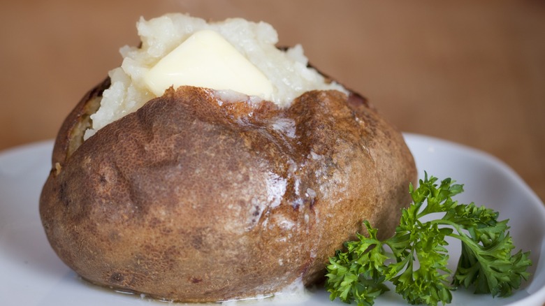 Baked potato opened with a pat of melting butter on top