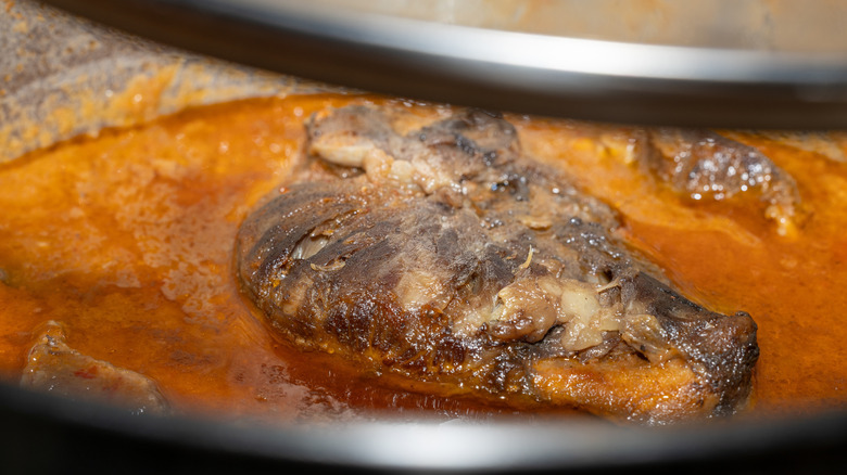 Pork being braised in red sauce