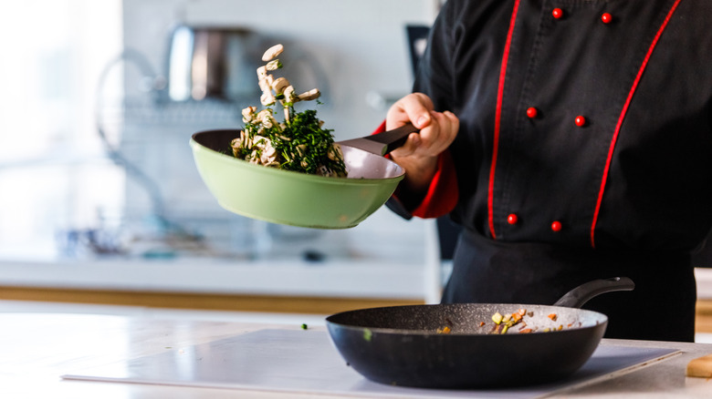 Chef tossing food in a saute pan