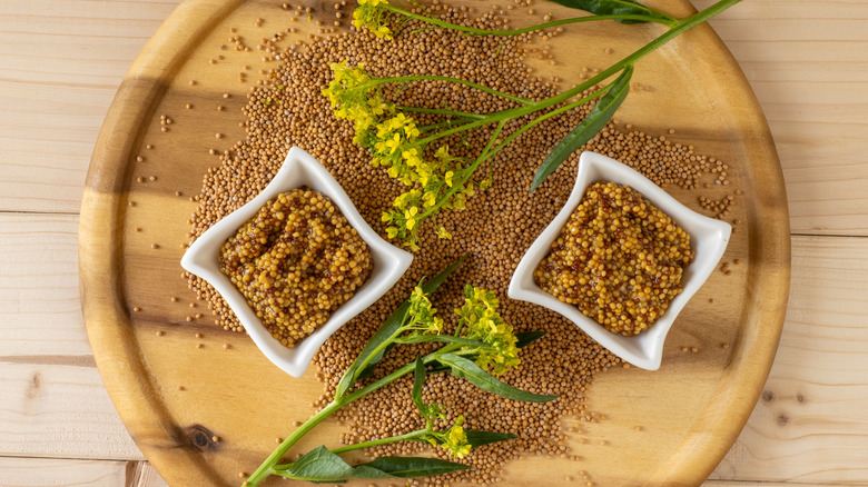 whole grain mustard with mustard seeds and mustard flowers