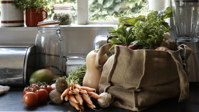 a reusable bag full of fresh produce on kitchen counter