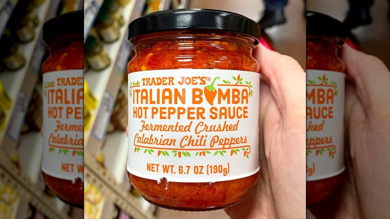 Hand holding a jar of Trader Joe's Italian Bomba Hot Pepper Sauce