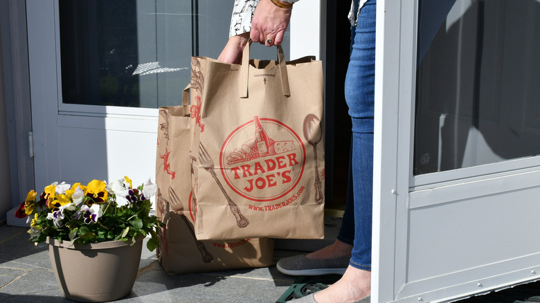 Person picking up two Trader Joe's paper bags
