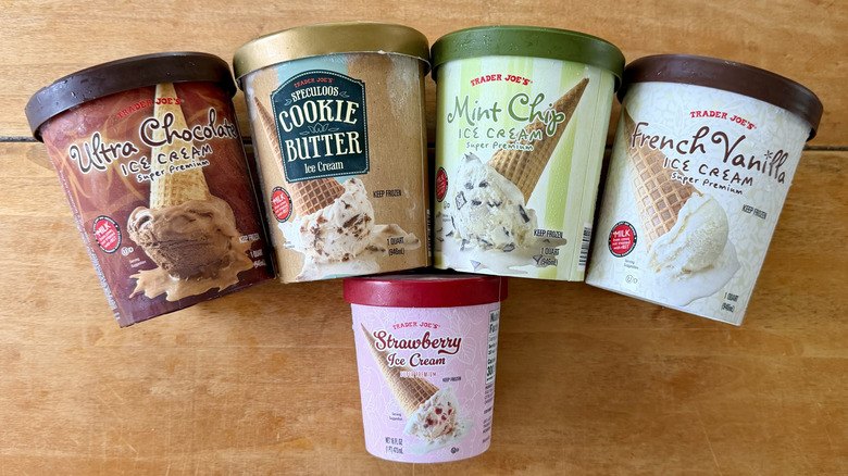 Five different Trader Joe's ice cream lined up on a wooden table