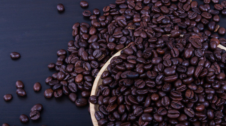 Dish overflowing with coffee beans