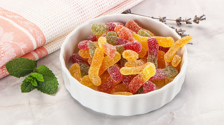 Small white dish full of colorful sour gummy worms