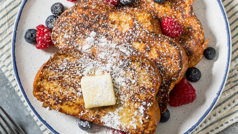 French toast on a plate with butter and berries