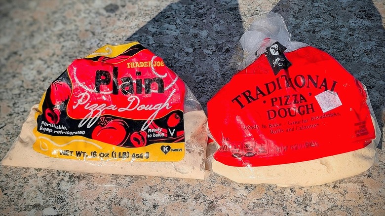 Two bags of Trader Joe's plain and traditional pizza dough on a kitchen counter