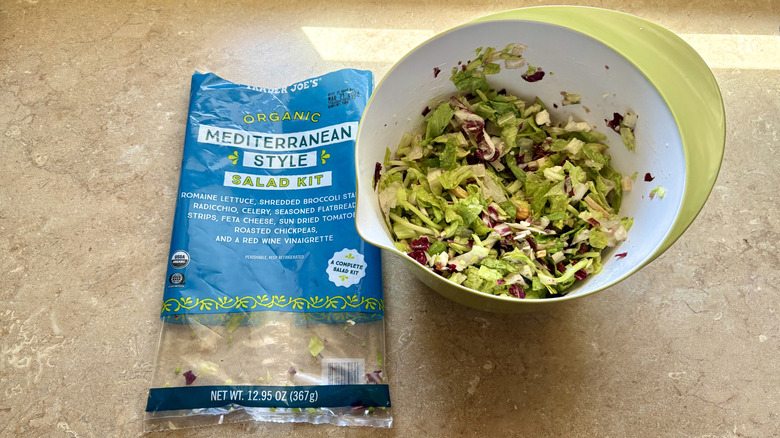 A prepared Organic Mediterranean Style Salad next to its empty bag