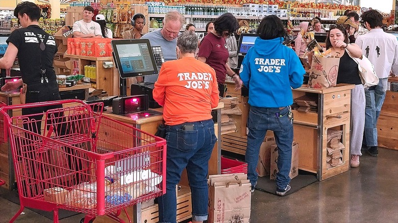 Trader Joe's employees helping customers and bagging groceries at check out