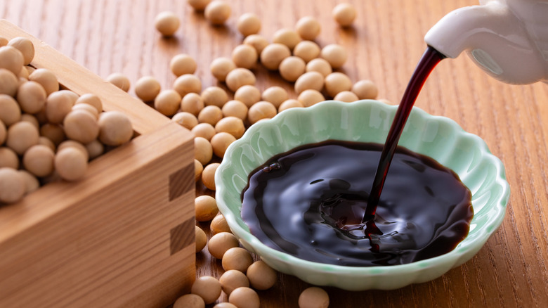 Soy sauce being poured into a small bowl.