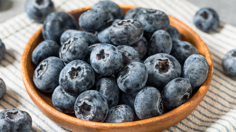Frozen blueberries in a wooden bowl