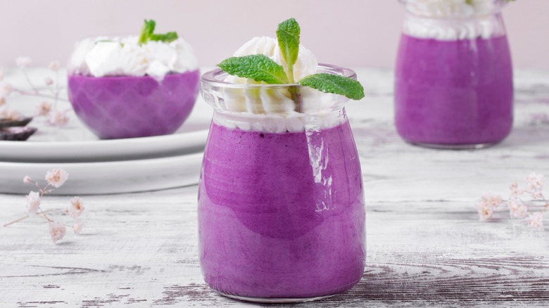 Several glasses of blueberry fluff on a farmhouse style table.