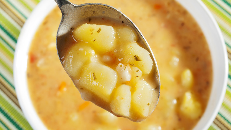 Potato soup in a spoon over a bowl