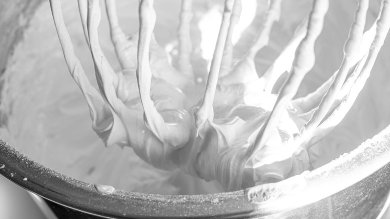 whisk inside of a bowl with frosting