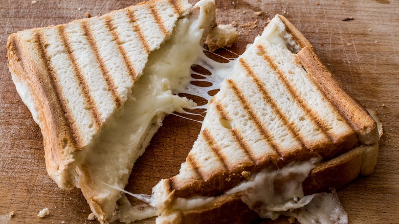 Grilled cheese sandwich on a rustic wooden cutting board