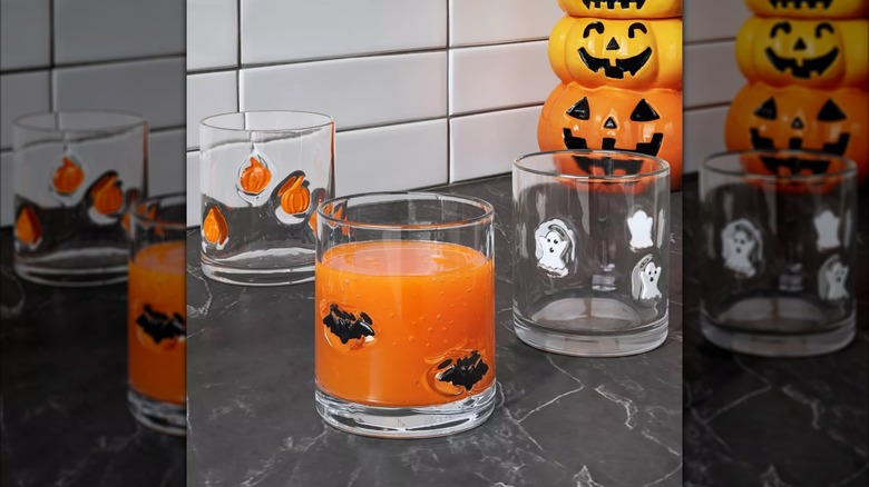 Three different rocks glasses with spooky designs from Target sitting on a kitchen countertop.