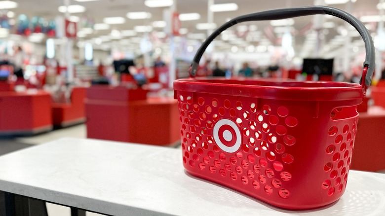 A red Target shopping basket sitting on a counter inside of a Target store.