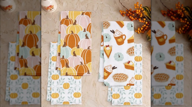 A set of fall print kitchen towels from Target featuring a pumpkin design and a fall latte design.