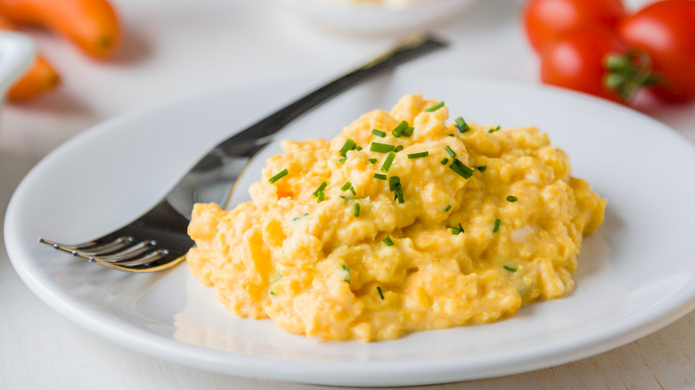 A plate with scrambled eggs and chives.