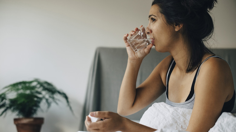 Woman in bed sipping water