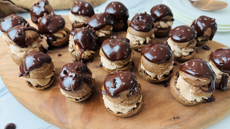 Chocolate cream puffs on wooden board