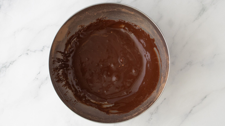 Chocolate glaze in bowl on marble surface