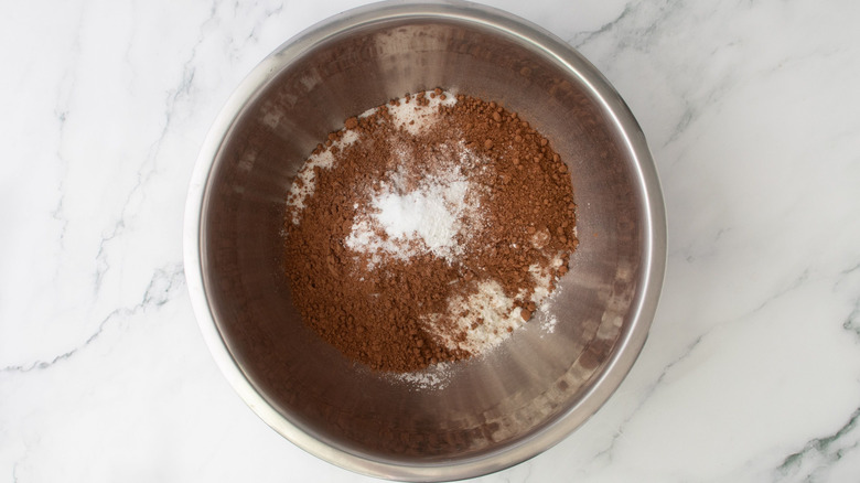 Aerial view of cocoa powder and flour mixture in bowl on marble surface