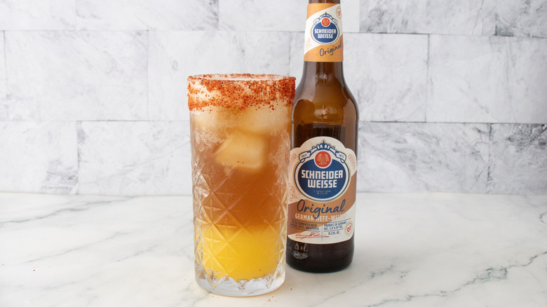 Tropical rum shandy in glass in front of beer bottle