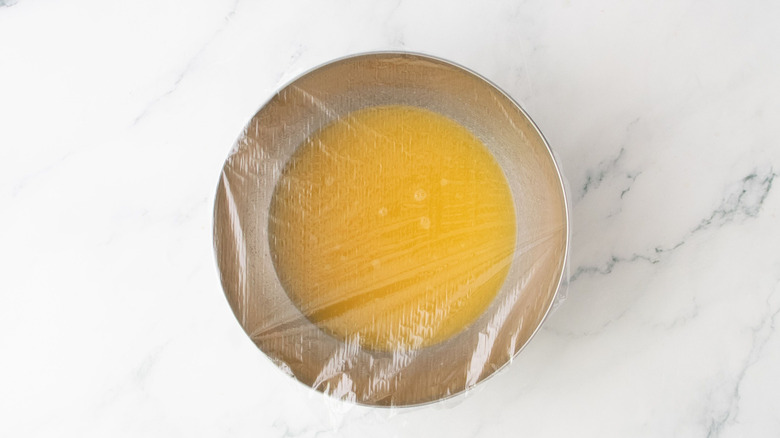 Tropical fruit juice in bowl covered with plastic