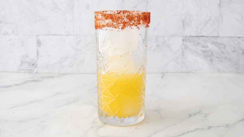 Tajín-rimmed glass partially filled with juice