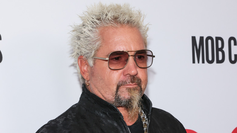 Guy Fieri in a leather jacket on a white backdrop