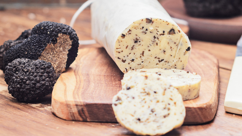 Truffles and truffle compound butter on a wooden cutting board