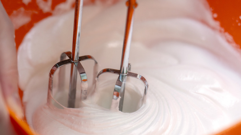 A hand mixer whipping egg whites.
