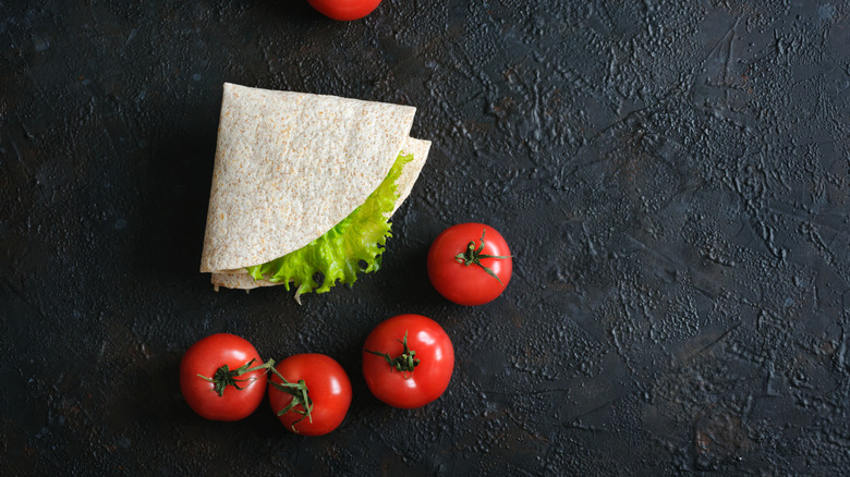 Tortilla triangle folded next to tomatoes