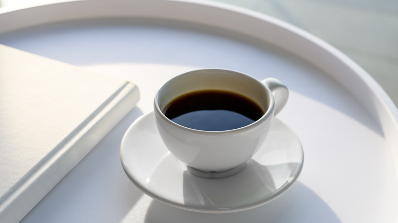 white coffee cup and book on a tray