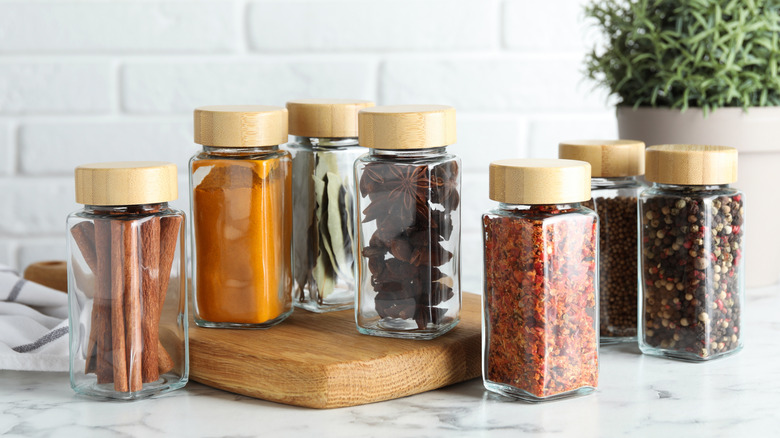 Different spices in glass jars on a kitchen counter