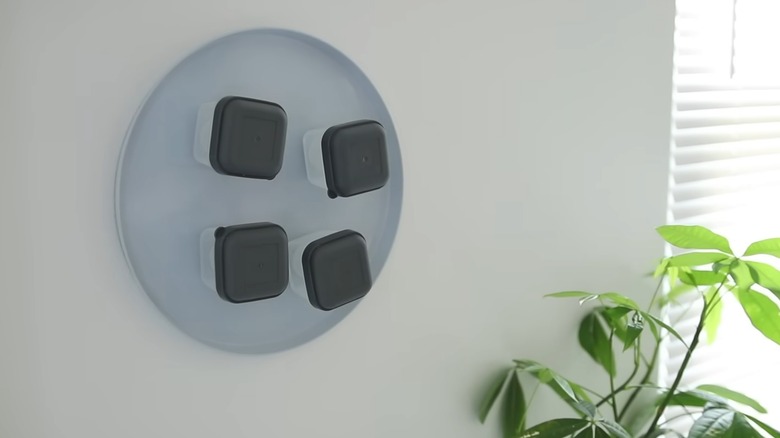 an image of this hack in action with a burner cover on the wall and magnetic mini tupperwares attached