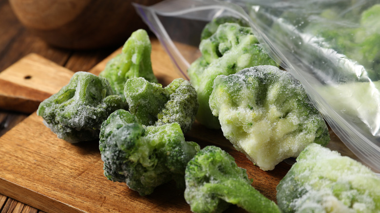 Frozen broccoli florets spilling out of a plastic bag