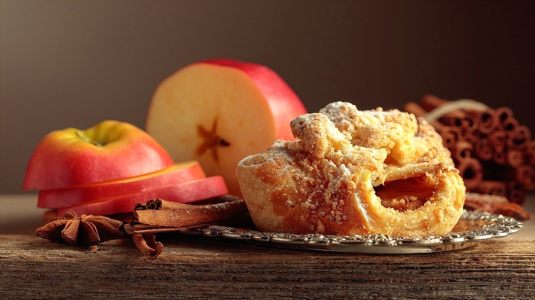 Streusel-topped sweet roll stuffed with apples on an ornate silver plate