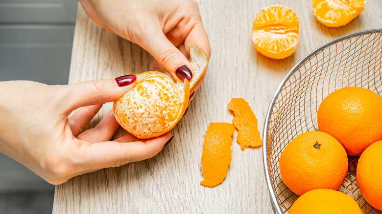 hands peeling citrus