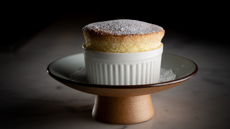A lovely soufflé in a white ramekin topped with powdered sugar.