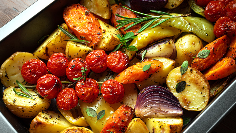 A pan of assorted roast vegetables sprinkled with fresh herbs
