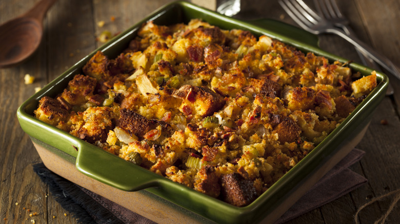 A dish of stuffing on a wooden table.