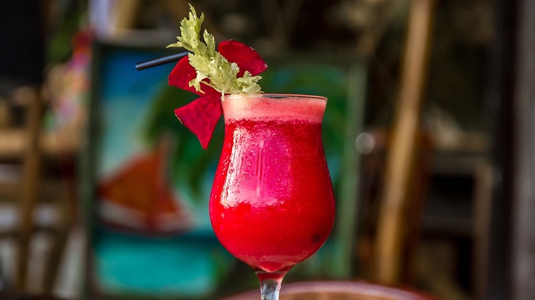 A red beetroot tequila cocktail includes a leafy garnish.