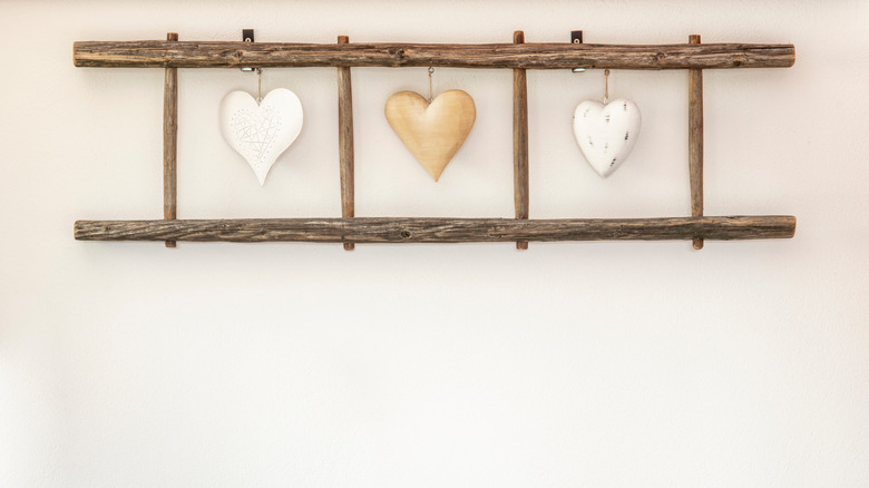 Old wooden ladder hanging horizontally on a wall with heart decorations